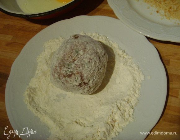 Облепить фаршем, постараться, чтоб фарш обхватил яйцо равномерно со всех сторон. Обвалять в муке, взбитом яйце.