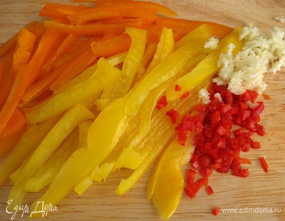 Из болгарского перца удалить семена и порезать соломкой. Из острого перца аккуратно удалить семена и мелко-мелко порубить. Чеснок почистить и пропустить через пресс.
