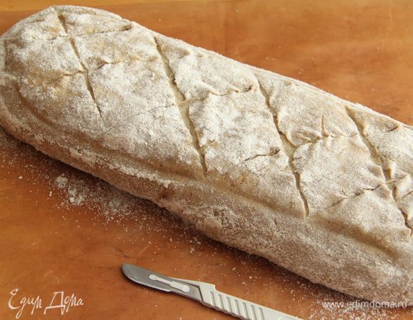 Через час перевернуть хлеб на антипригарный коврик, присыпанный манкой или ц/з мукой. С помощью скальпеля сделать надрезы.