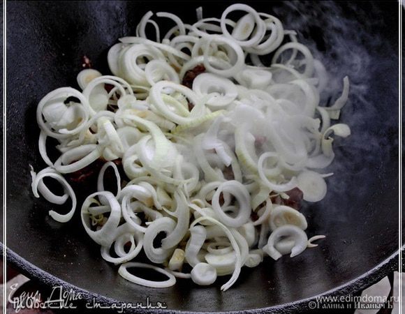 
Лук, как вы помните, уже нарезан, и тут можно пойти двумя путьми.
Первый – это когда сначала поджарим лук, а второй – прежде лука обжарим мясо. Кости (больше для удовольствия) и большие куски мяса, которые потом используем для плова. 
Лук надо закладывать в раскалённое, опять-таки, масло. Вот такая реакция сразу образовывается.
И жарим его. Перемешивая. Чтобы не пригорело.
