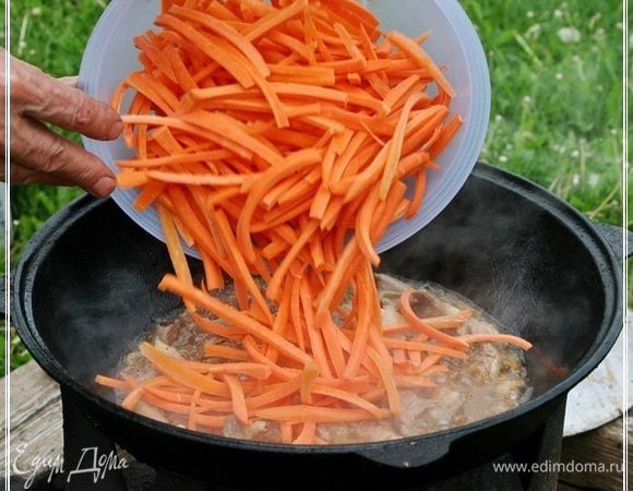 И пришло время морковки. Высыпаем ее в казан. Поверх мяса. 