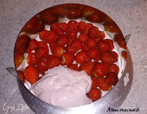 У нижнего коржа установить контур, выложить 1/3 крема. Поверх 3/4 клубники (остаток нам нужен для украшения), затем заполнить оставшимся кремом. Накрыть вторым коржом и поставить в холодильник на 6 часов, лучше на ночь.