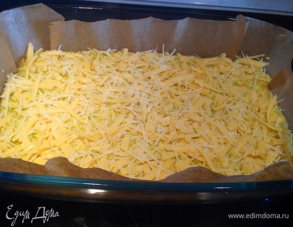 Форму выстелить пекарской бумагой и выложить в нее смесь, сверху посыпать сыром...