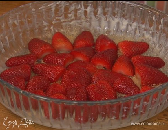 Жаропрочную стеклянную или керамическую форму смазать сливочным маслом, присыпать дно сахаром и выложить клубнику срезами вниз.