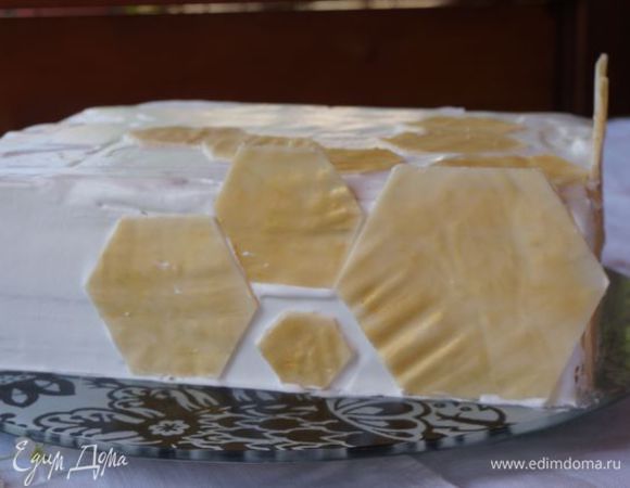 Когда торт постоит в холодильнике, обмазываем бока и верх кремом, украшаем либо крошкой от коржей, либо орехами, либо вот так, белым шоколадом. Здесь около 80 г шоколада, растопила на водяной бане с ложечкой сливок, вылила на ровную поверхность, подморозила, по трафарету вырезала "пчелиные соты", покрыла сухим кандурином.