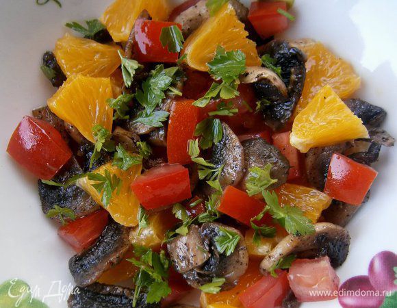 Апельсин очистить и нарезать кубиками. Помидор нарезать кубиками, без мякоти. Зелень петрушки измельчить. Добавить обжаренные  грибы, перемешать.