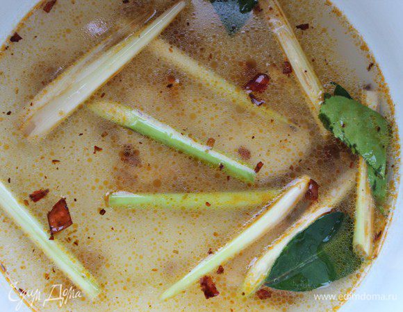 Довести до кипения бульон, опустить в него лемонграсс, галангал и листья лайма. Чтобы листья полностью раскрыли свой аромат, нужно удалить из них черешок посередине. Добавить чесночно-перечную пасту и варить 1–2 минуты.