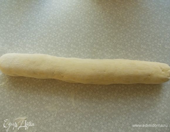 Достаем тесто из холодильника. Посыпаем обильно стол мукой и выкладываем тесто. Делаем "колбаску".