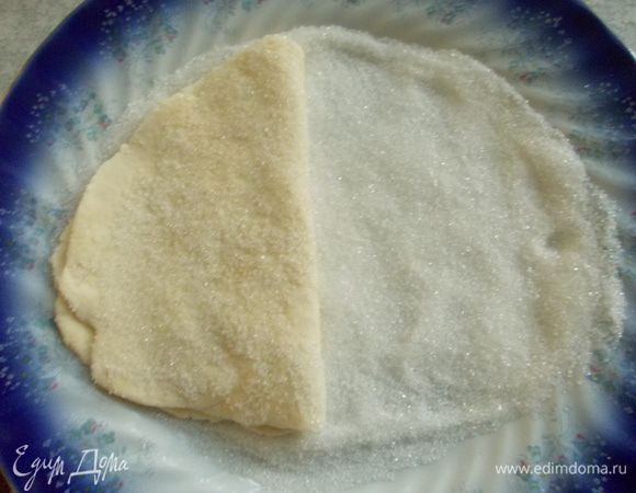 Переворачиваем тесто и опять вдавливаем в сахар. Затем складываем тесто  пополам. 