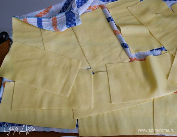 Заранее поставить на огонь большую кастрюлю с водой. Как только вода закипит, посолить и положить в нее пласты теста для лазаньи..., буквально на 1 минуту. Затем достать листы лазаньи и выложить их на чистое кухонное полотенце. 