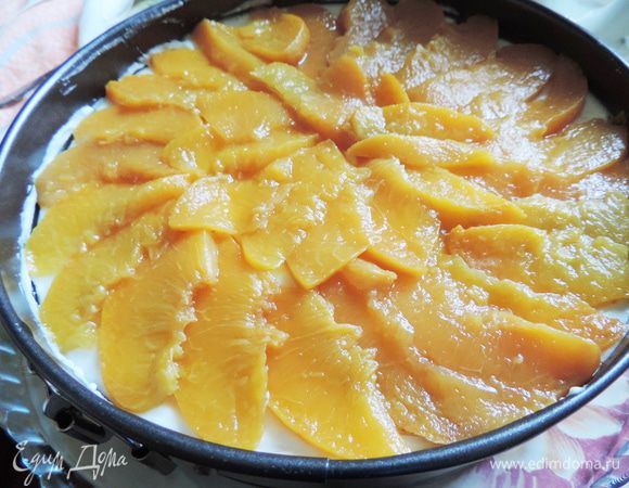 Для торта нам понадобится большая банка персиков. У меня были персики в сиропе домашнего приготовления. Банка объемом 750мл. Персиков мне хватило в обрез. Сироп сливаем и используем для желе и пропитки бисквита. 
Кладем на блюдо наш бисквит, заключаем его в кулинарное кольцо или бортик формы, в которой он выпекался. Бисквит пропитываем персиковым сиропом (примерно 100мл).
Персики нарезаем на тонкие пластинки и выкладываем сверху на суфле.