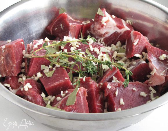 Чеснок очистить и измельчить, лавровый лист поломать руками на небольшие кусочки. Измельченный чеснок, лавровый лист и тимьян добавить к мясу.