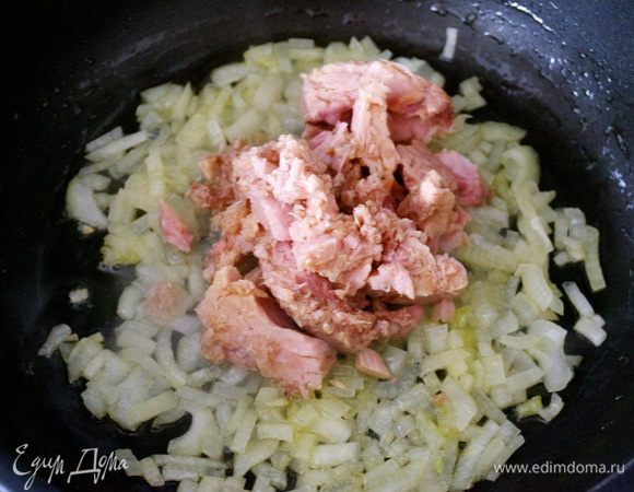 Как только лук посветлеет, добавить к нему консервированный тунец. 