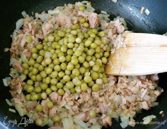 Если используете консервированный зеленый горошек, добавить его в сковороду и тушить все вместе около 3-х минут. Замороженный горошек тушить около 10 минут.   