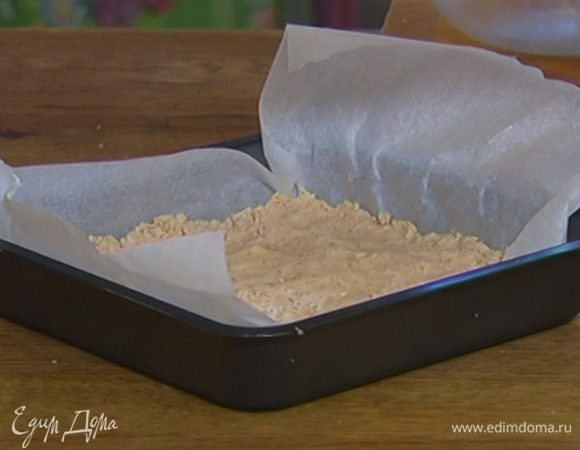 Небольшой противень выстелить бумагой для выпечки и равномерно выложить тесто пластом толщиной в 1 см.