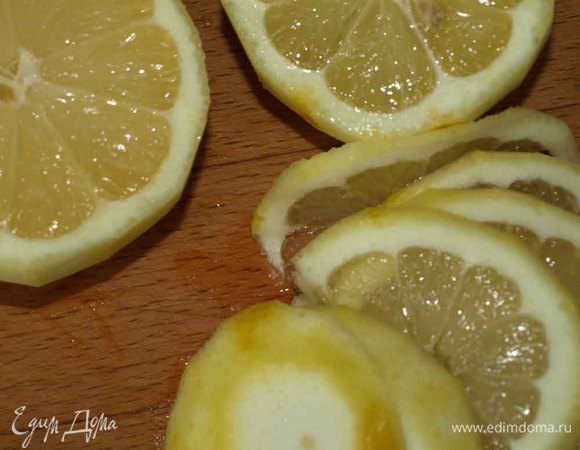Лимоны режем на четыре части. Одну часть режем кружками и добавляем в чай. Из остальных выжимаем сок и добавляем его в чай. 