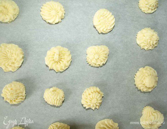 На застеленный пекарской бумагой противень отсаживаем печенье на расстоянии 2-3 см.