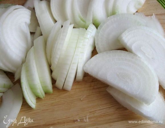 Приготовить начинку. Лук почистить (у меня был достаточно крупный лук), порезать полукольцами. Колбасу почистить, порезать кружочками.