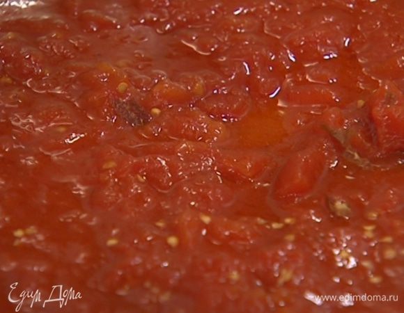 В ту же сковороду выложить консервированные помидоры, добавить измельченный пеперончино, сахар и прогревать, перемешивая, чтобы получился однородный соус.