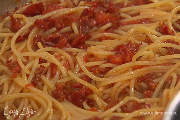 Готовые спагетти выложить в сковороду с соусом, все перемешать, добавить вяленые помидоры, оставшееся оливковое масло и еще раз перемешать.