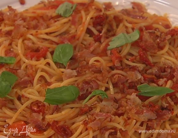 Спагетти с соусом выложить в большую тарелку, посыпать измельченным беконом и листьями базилика.