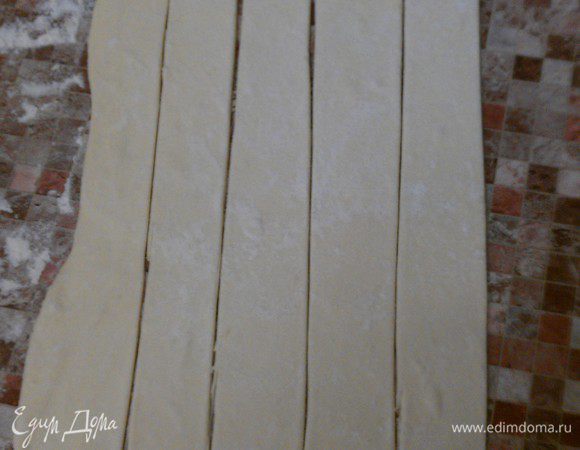 Размороженное тесто тонко раскатать (1-2 мм по толщине). 
Порезать на полоски 3 см по ширине и 30 см по длине.