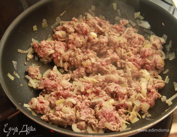 Добавить фарш, обжарить ещё минут пять, перемешивая. Фарш с луком убрать из сковороды.