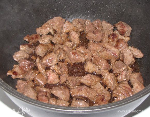 Разогреть в кастрюле с толстым дно растительное масло и обжарить кусочки баранины до золотистого цвета.