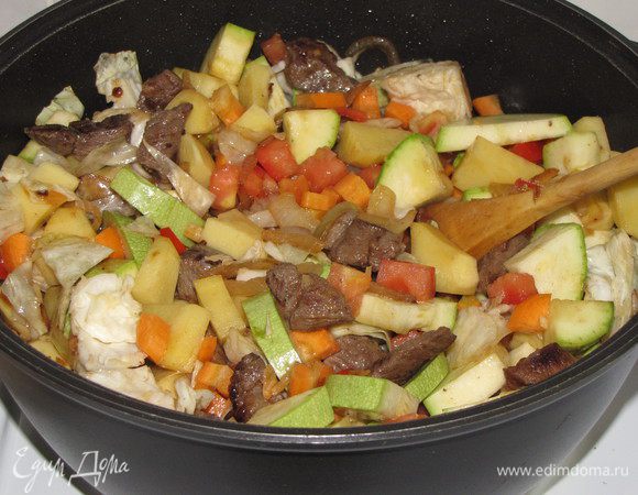 Добавить морковь и помидоры. Влить 2 стакана подсоленного кипятка и тушить на медленном огне 1,5-2 часа.