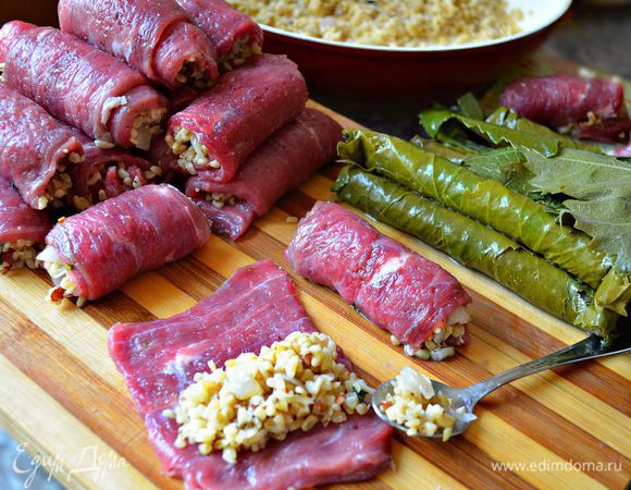На каждый кусочек мяса укладываем подготовленную начинку, плотно сворачиваем. Большие рулетики можно разделить пополам. Затем каждый мясной рулетик заворачиваем в виноградный лист.