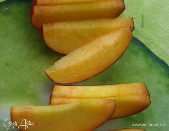 Нектарин нарезать тонкими дольками и выложить на листья салата.