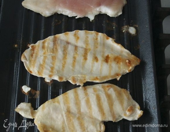 В это время приготовьте начинку-салат. Разогрейте сковороду-гриль и смажьте решетку слегка маслом. Куриные грудки обжарьте по 8 минут с каждой стороны или пока сок при прокалывании не станет прозрачным.  