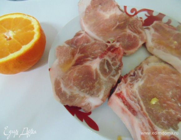 Мясо свинины на косточке помыть, обсушить бумажными полотенцами. Каждый кусок мяса весом 150-200 грамм. Выжать на мясо сок из половины апельсина. Оставить мариноваться на полчаса.
