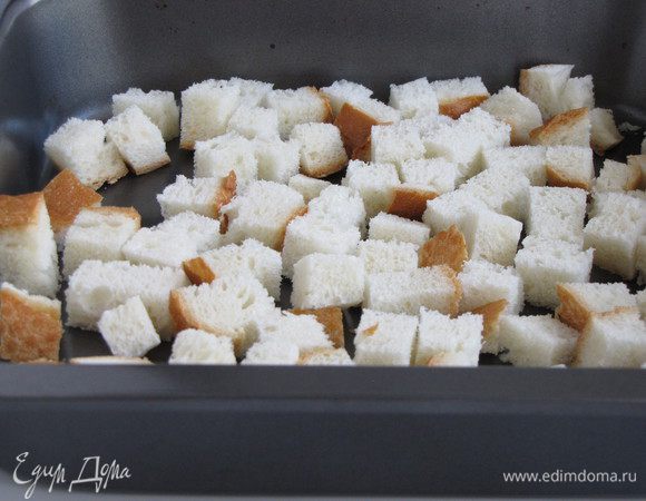 Сначала приготовим сухарики. Батон нарезать небольшими кубиками, выложить на противень и запечь в духовке до золотистого цвета.