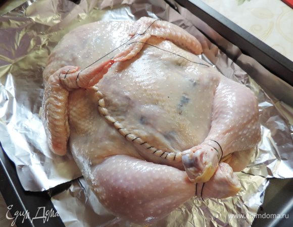 Нам осталось скрепить кожу в местах разрезов. В области шейки я кожу просто подогнула под курицу, а снизу большой разрез зашила. На фото видно, что кожица была дополнительно заштопана. 
Ножки и крылышки связываем грубой ниткой, придавая им нужное положение. Перекладываем курочку на подготовленный противень.