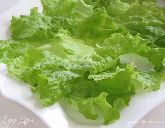 Листья салата вымыть и обсушить на полотенце или в специальной сушилке для зелени. Порвать руками на небольшие кусочки и выложить на блюдо. Для «Цезаря» подойдет салат айсберг, латук, романо, а также китайская капуста.