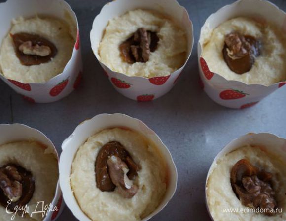 Из данного количества теста получается 8 больших, либо 12 маленьких кексов. На дно каждой формочки (здесь - одноразовые картонные) кладем по 1 или 2 (в зависимости от размера формы) столовой ложке теста, сверху - 0,5 чайной ложки сгущенки, четверть или половинку орешка.