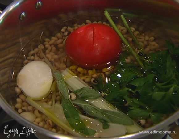 Фасоль, помидор, сельдерей, петрушку, пару листиков шалфея, почищенные лук и чеснок, поместить в кастрюлю, залить водой, влить оливковое масло и варить до готовности фасоли без добавления соли.