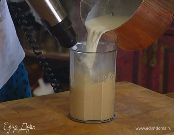 Продолжая взбивать, тонкой струйкой влить горячие сливки с молоком и взбить еще немного.