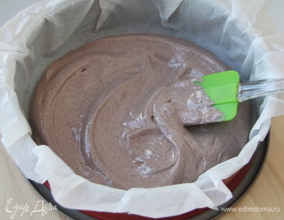 Разъёмную форму застелить бумагой для выпечки, ничем не смазывать. Выложить половину теста.