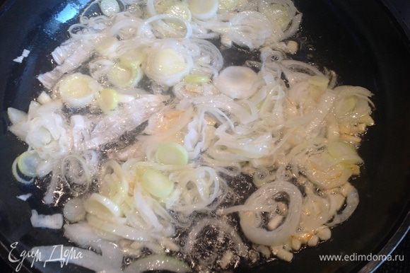 Разогрейте растительное масло на большой сковороде и обжаривайте на ней репчатый лук, лук-порей и чеснок 5 минут до мягкости. Добавьте свинину и обжаривайте еще 5 минут.