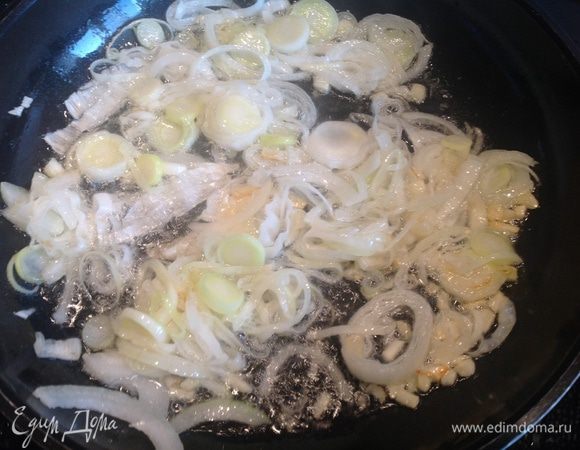 Разогрейте растительное масло на большой сковороде и обжаривайте на ней репчатый лук, лук-порей и чеснок 5 минут до мягкости. Добавьте свинину и обжаривайте еще 5 минут.