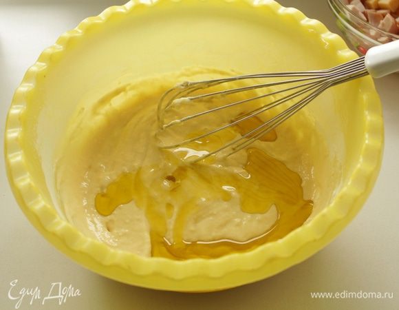 Продолжая взбивать, добавляем оливковое масло и ещё раз перемешиваем. Тесто должно получиться жидким.