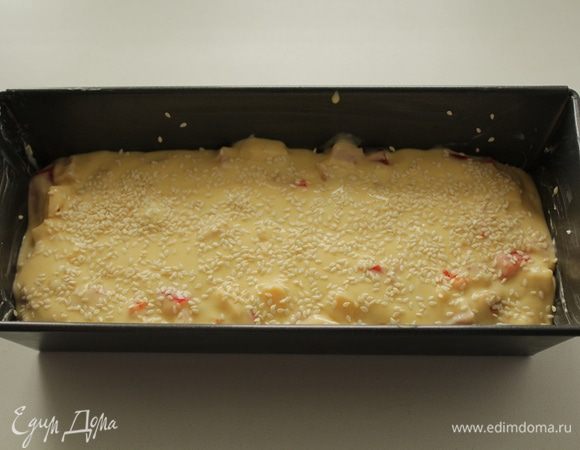 Добавляем начинку и  перемешиваем. Заливаем тесто в смазанную форму для запекания. Сверху кекс  посыпать кунжутом.