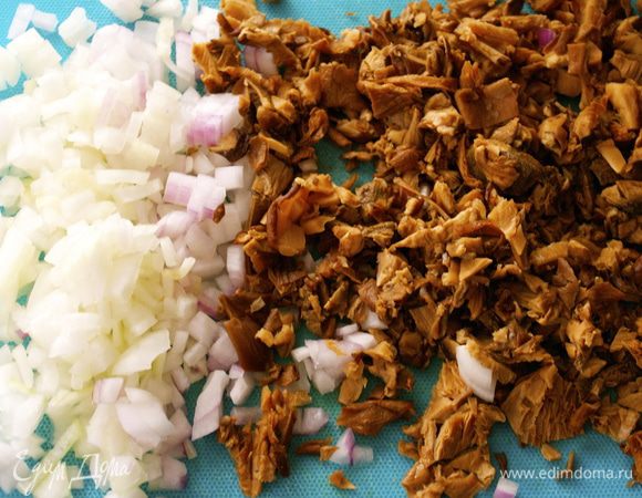 Замоченные грибы отжать от лишней жидкости и мелко порубить. Луковицу также очистить и измельчить. 