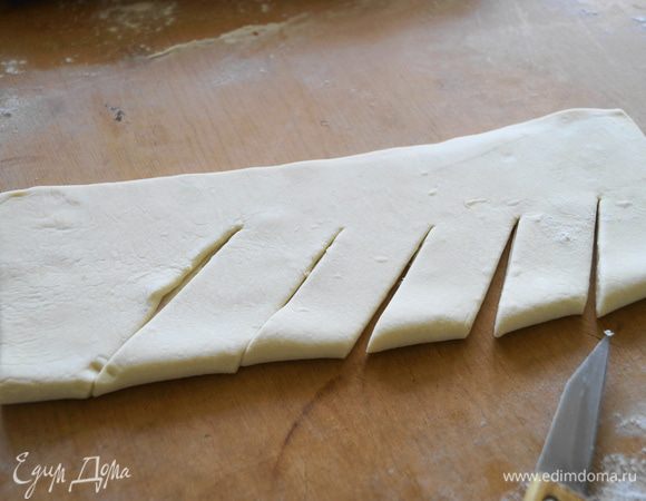 Для того, чтобы покрыть верх пирога необходимо раскатать такой же пласт теста, сложить его вдвое и сделать надрезы.