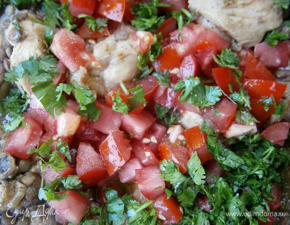 Добавить готовую чечевицу, нарезанные помидоры и зелень кинзы, перемешать и готовить ещё 5 минут.