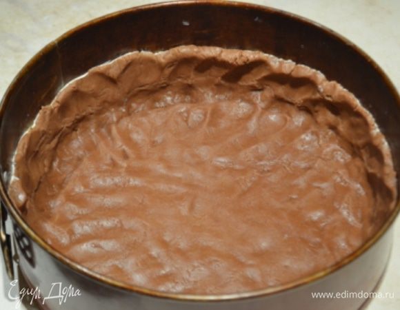 Разъемную форму диаметром 22 см смазать сливочным маслом и руками по нему распределить тесто, сформировать бортики около 4 см высотой, наколоть вилкой и убрать в холодильник на 20 минут, затем испечь корж примерно 20 минут при 200°C.