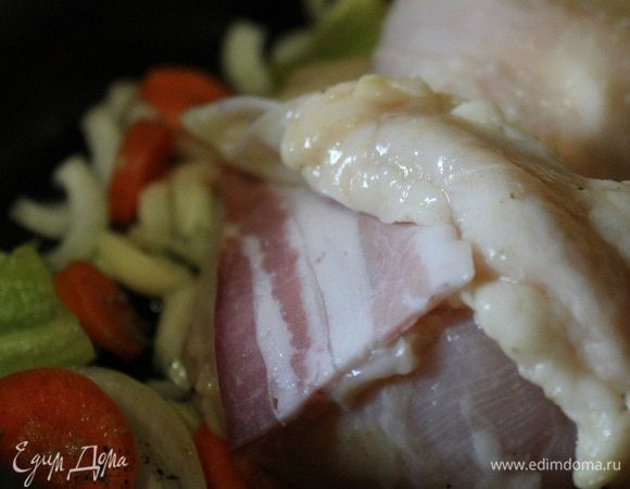 Один ломтик бекона положить под кожу на грудку. Второй ломтик разрезать на две части и обмотать кончик крылышка и ножки.