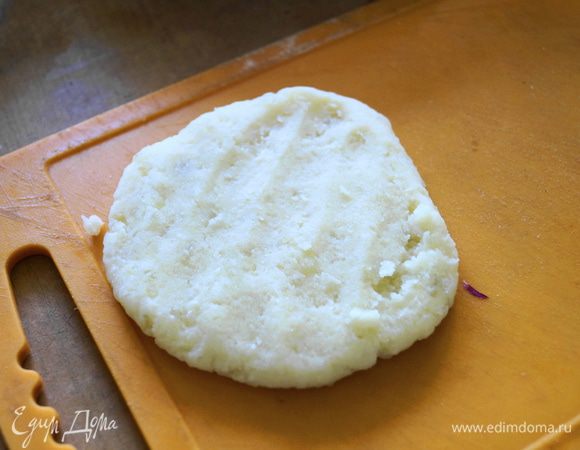 В ладонь взять немного картофельного теста и скатать в шарик. Приплюснуть его, так чтобы получилась лепешка